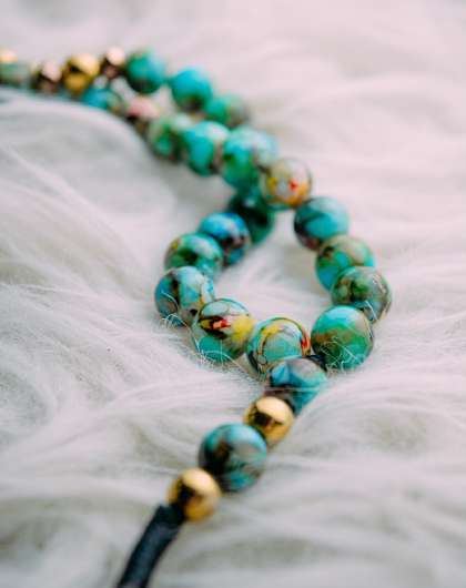 beaded blue and gold necklace on white faux fur