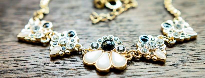 close up of ornate necklace on wooden table