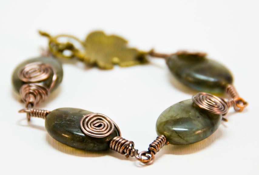 small necklace with chunky oval green gems and gold spiral details